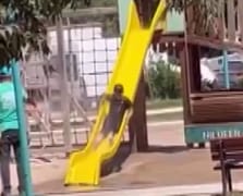 Sıcak havada parkta oynayan çocukları hortumla su sıkarak serinletti