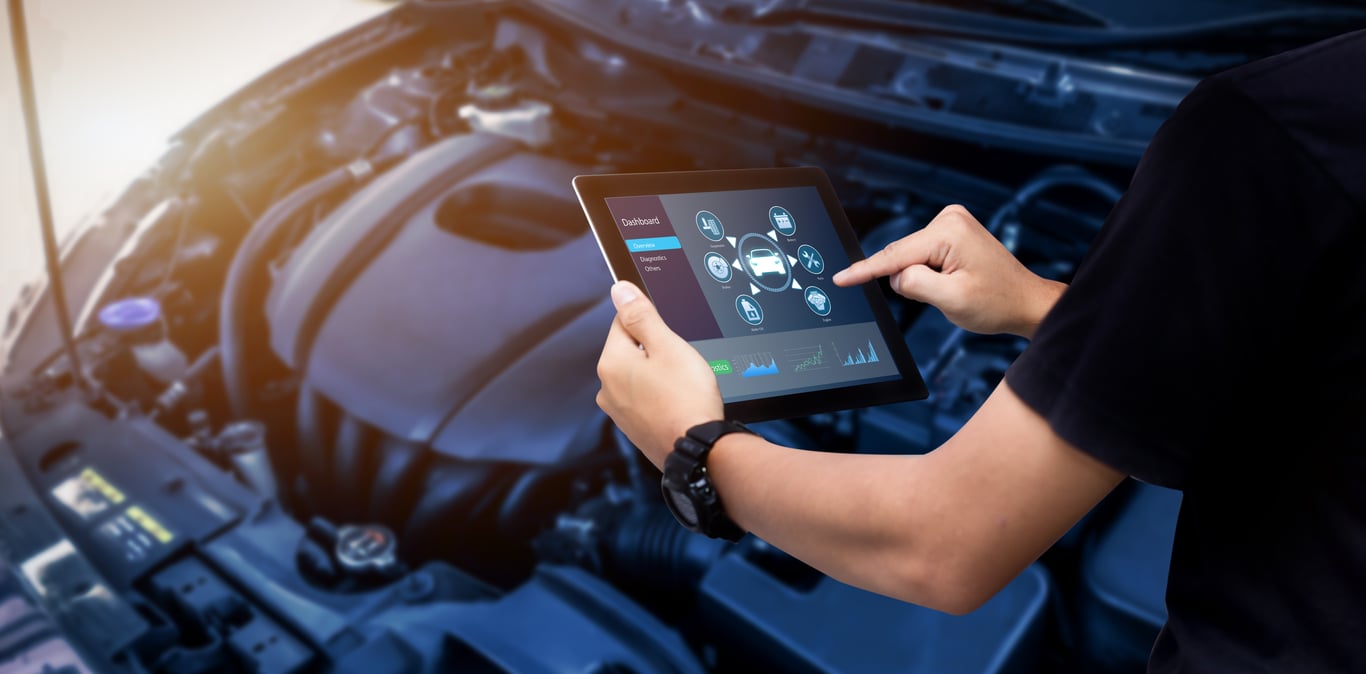 Technician using digital diagnostic tools for automotive repair and engine system inspection