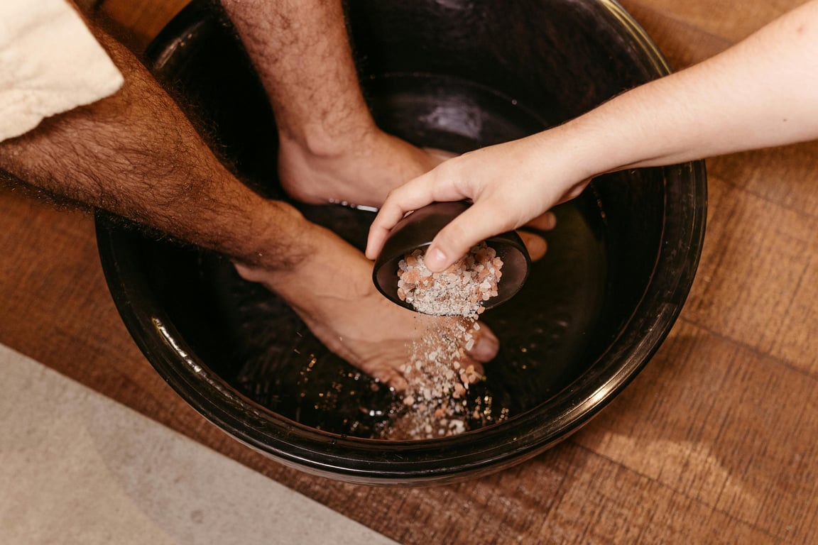 Man enjoying a soothing foot soak with Himalayan salt in a relaxing spa setting.