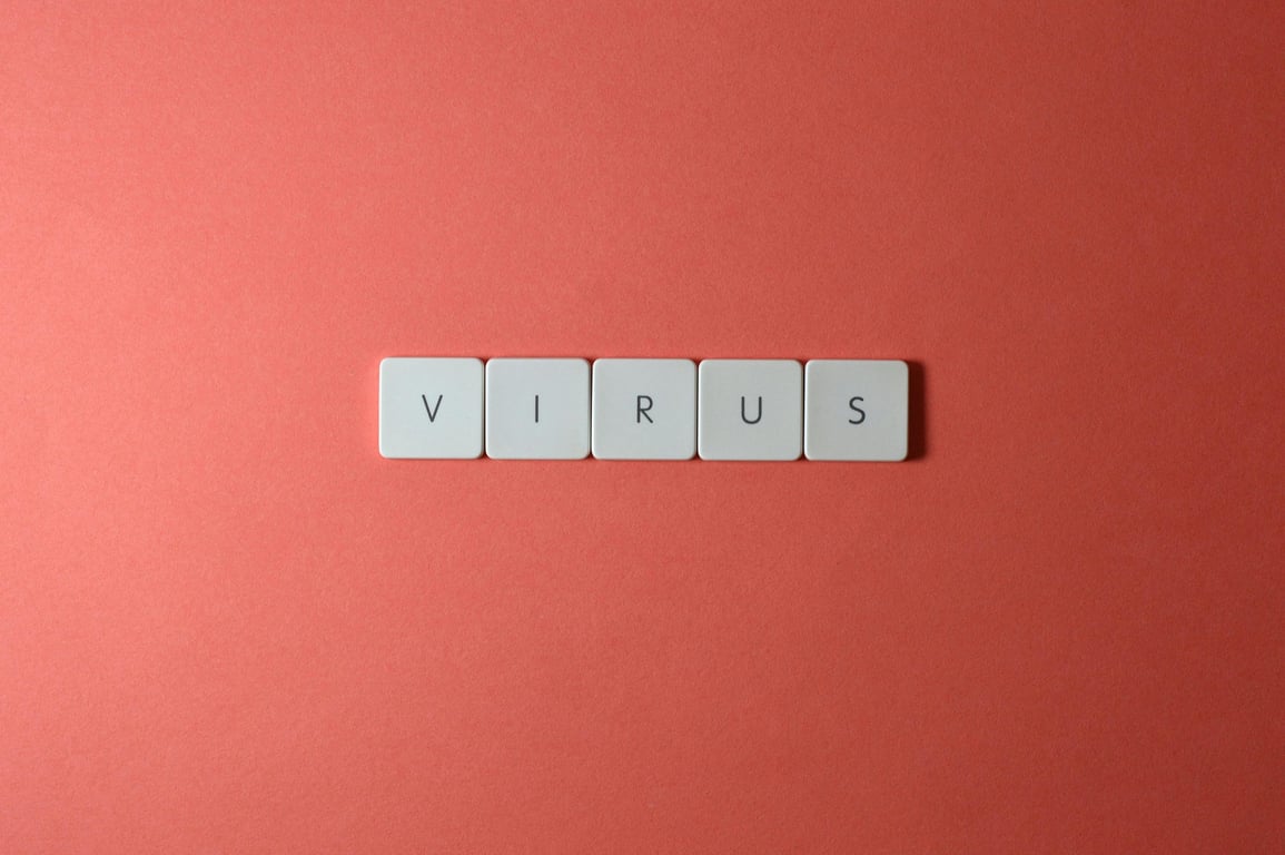 Close-up of keyboard keys spelling 'virus' against a red background, ideal for conceptual use.