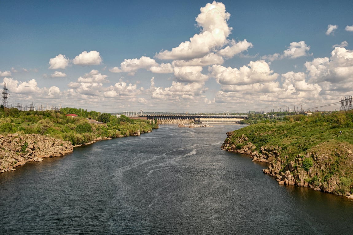 Breathtaking view of the Dnipro River and dam under a partly cloudy sky in Zaporizhzhia, Ukraine.