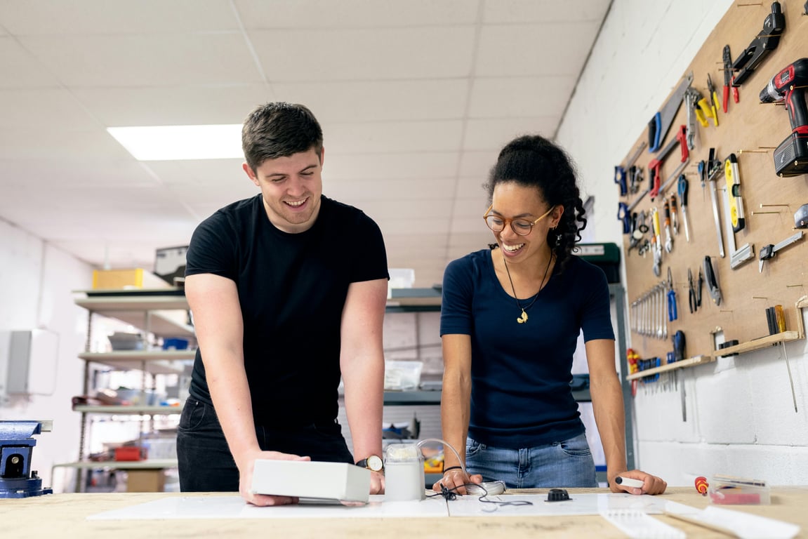 Two engineers collaborate in a workshop, engaging in hands-on prototyping and design.