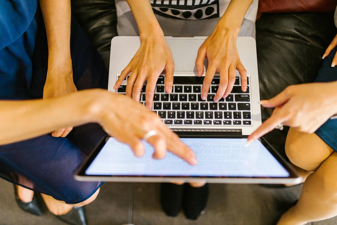 Team members working collaboratively around a laptop, focusing on a project.
