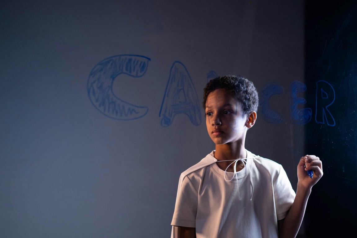 A young boy stands indoors holding a marker, raising cancer awareness.
