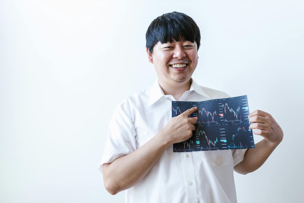 Smiling man presenting cryptocurrency investment chart indoors.
