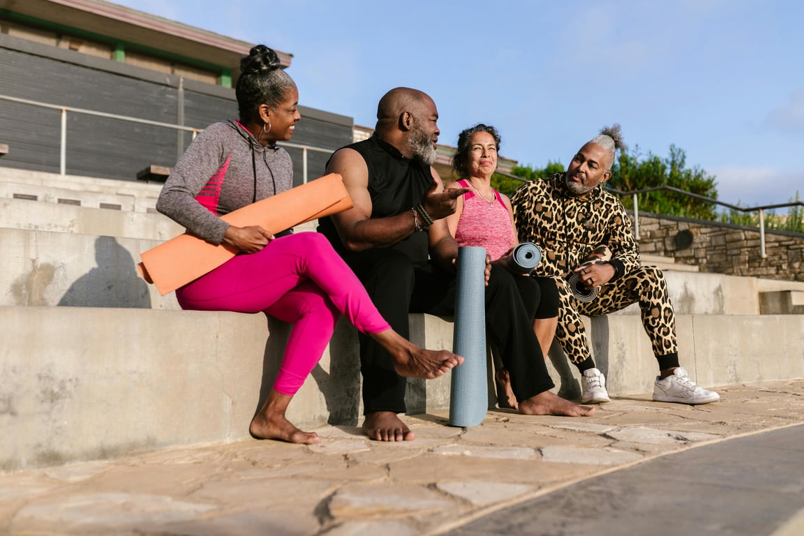 A diverse group of seniors relaxing with yoga mats outdoors, embracing wellness and togetherness.