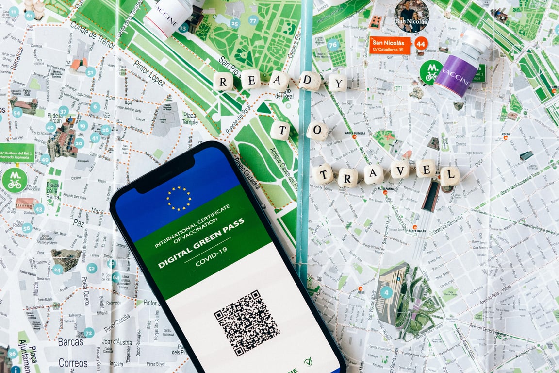 Digital Green Pass on phone with map background and travel concept.