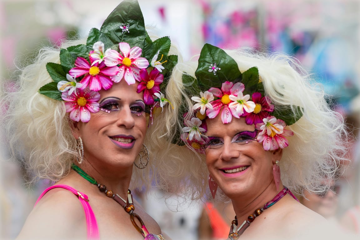 Vibrant portraits of two individuals with floral crowns at the Tilburg Pride Parade.