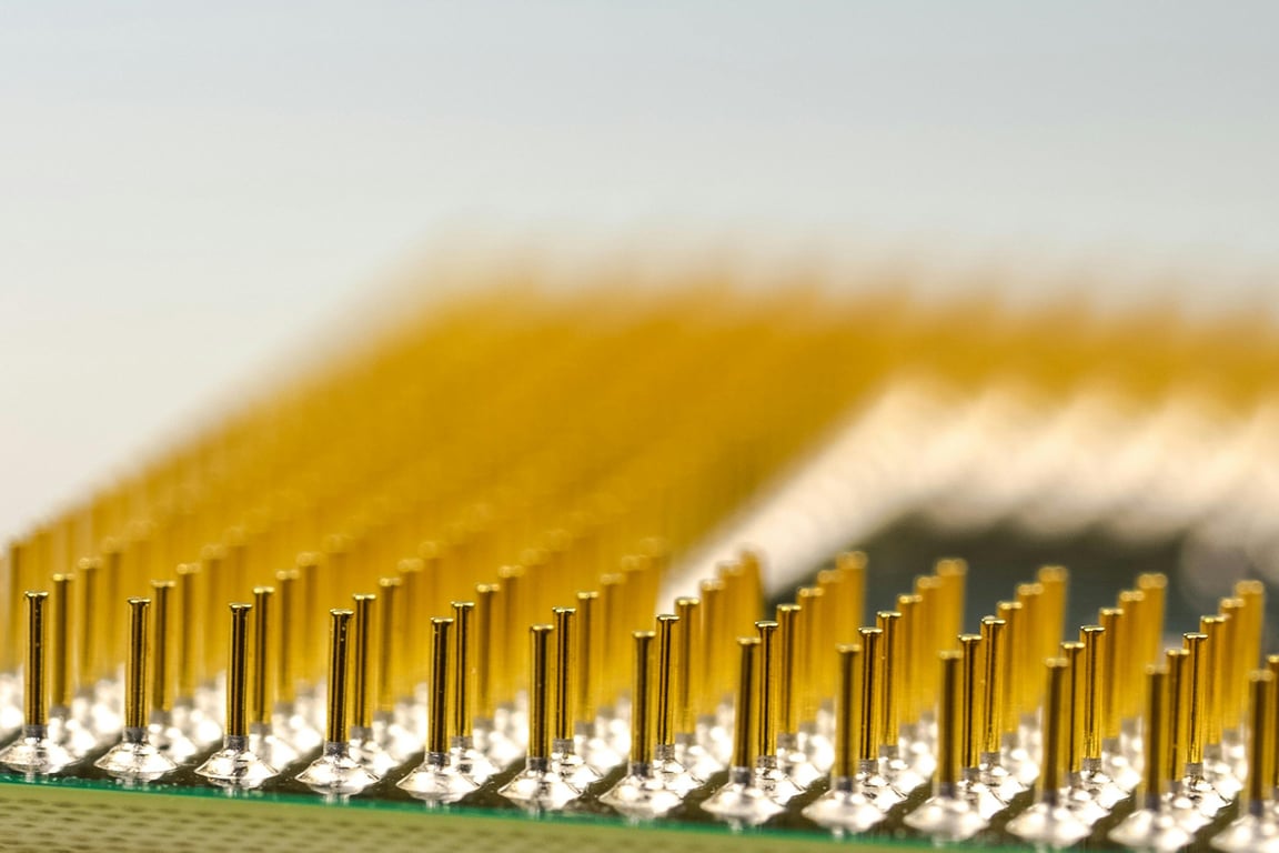 Detailed macro shot of a CPU microchip with focus on golden pins, highlighting technology details.