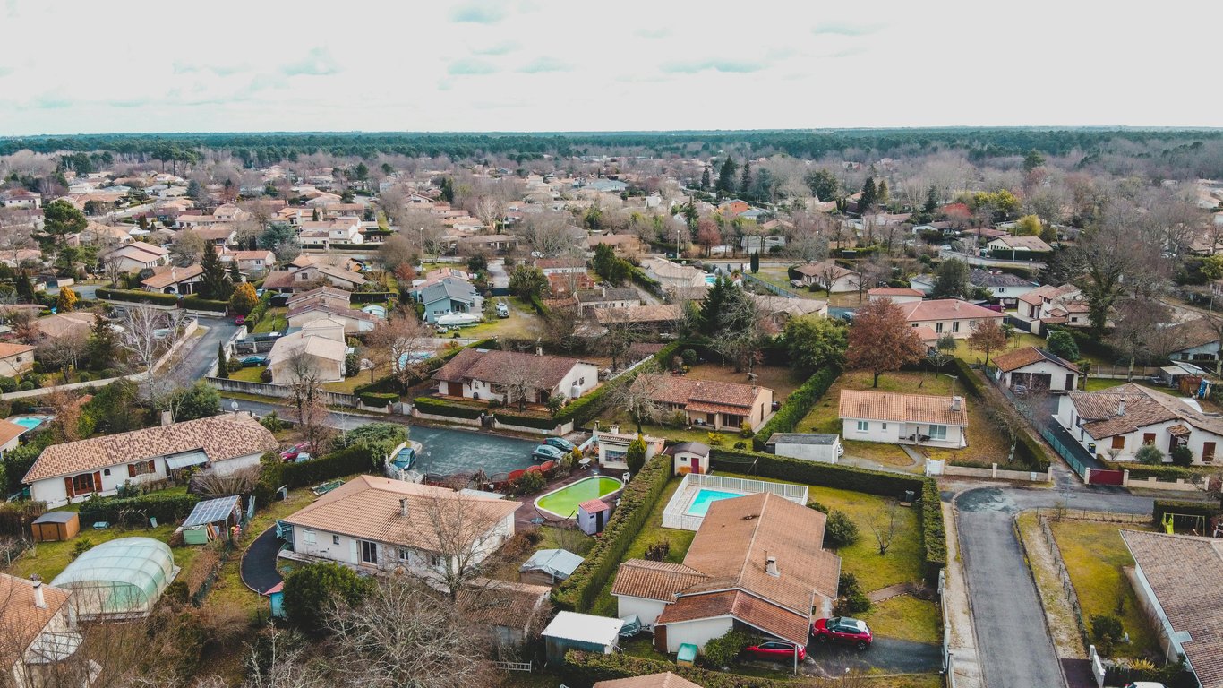 Drone view of residential neighborhood in Bordeaux, France showcasing suburban homes and greenery.