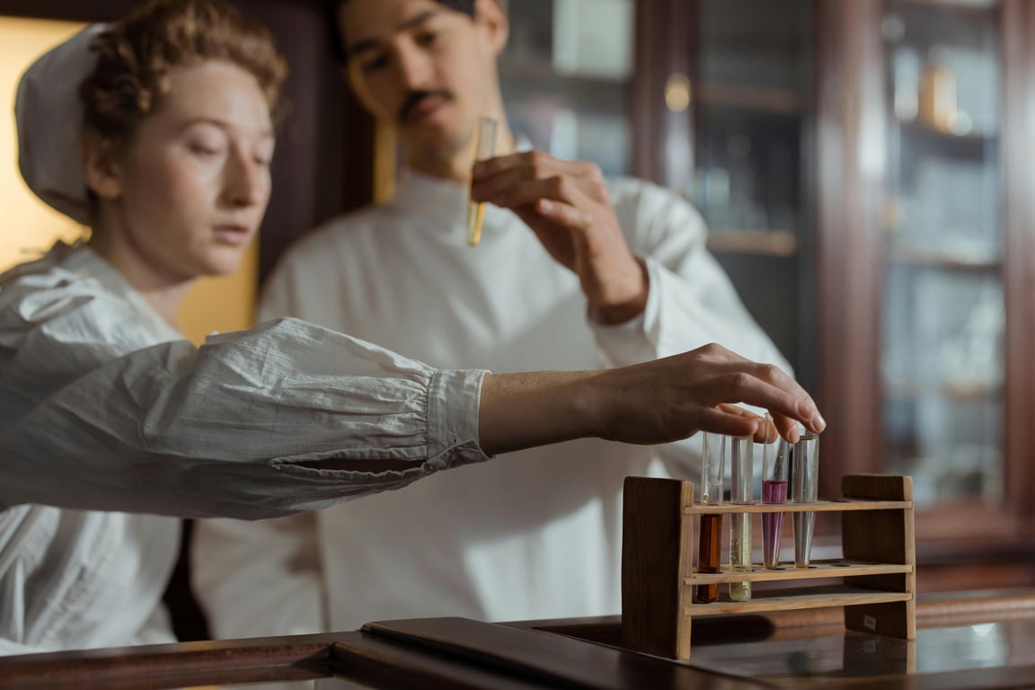 Researchers in a lab examining test tubes with colored liquids for experiments.