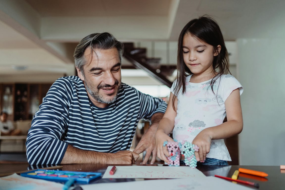 A joyful father and daughter bonding while engaging in creative activities at home.