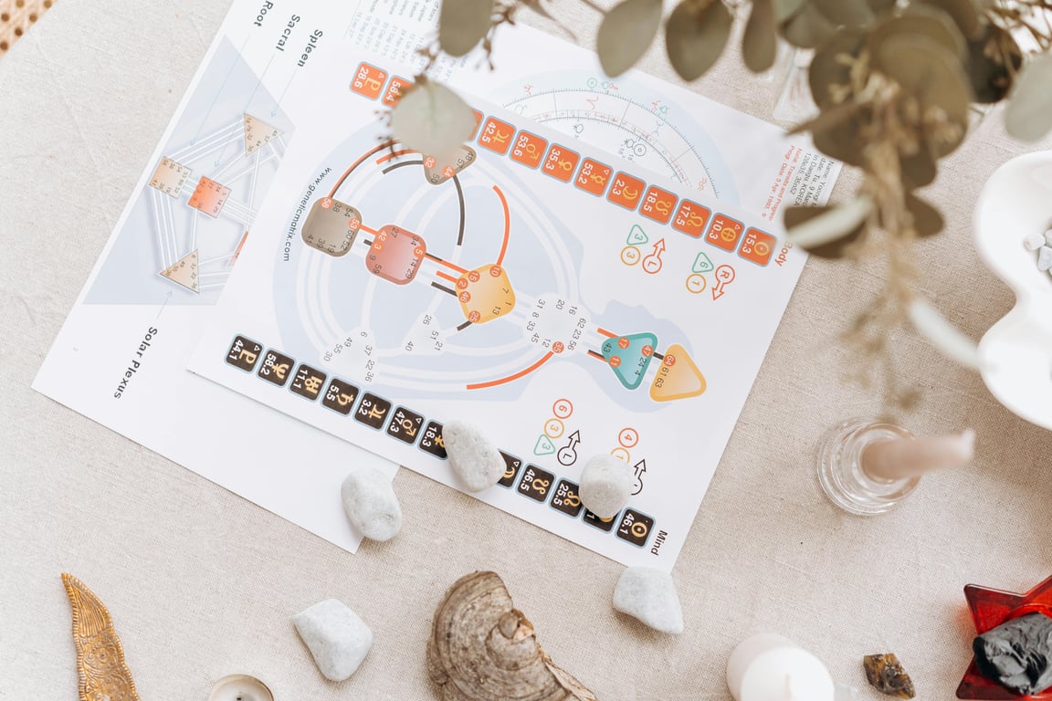 A serene setup of spiritual diagrams and crystals on a beige surface, symbolizing holistic healing and balance.