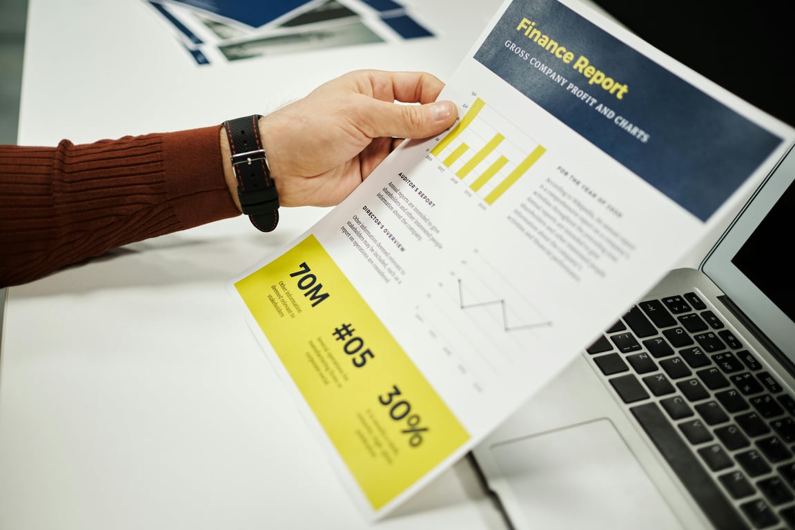Person analyzing finance report with graphs at desk, ideal for business concepts.
