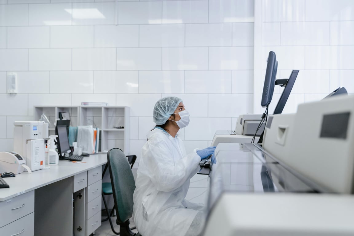 Scientist wearing protective gear conducts research in a modern lab setting.