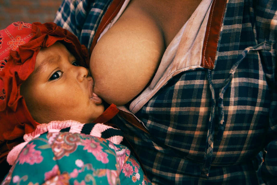 Close-up of a mother breastfeeding her baby, showcasing motherhood and bonding.