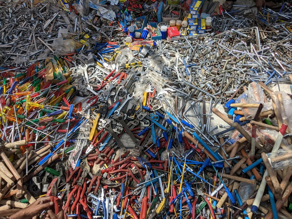 Vibrant collection of various hand tools scattered in an outdoor market in Lucknow, India.