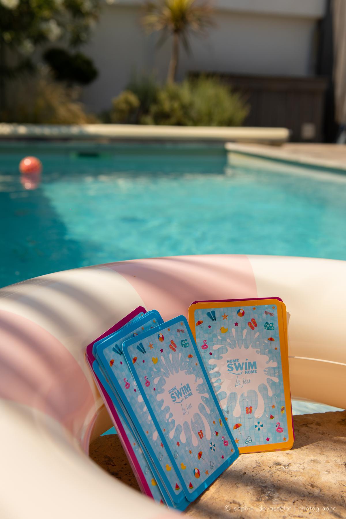 Les cartes de Home Swim Home, le jeu, dans une bouée au bord de la piscine