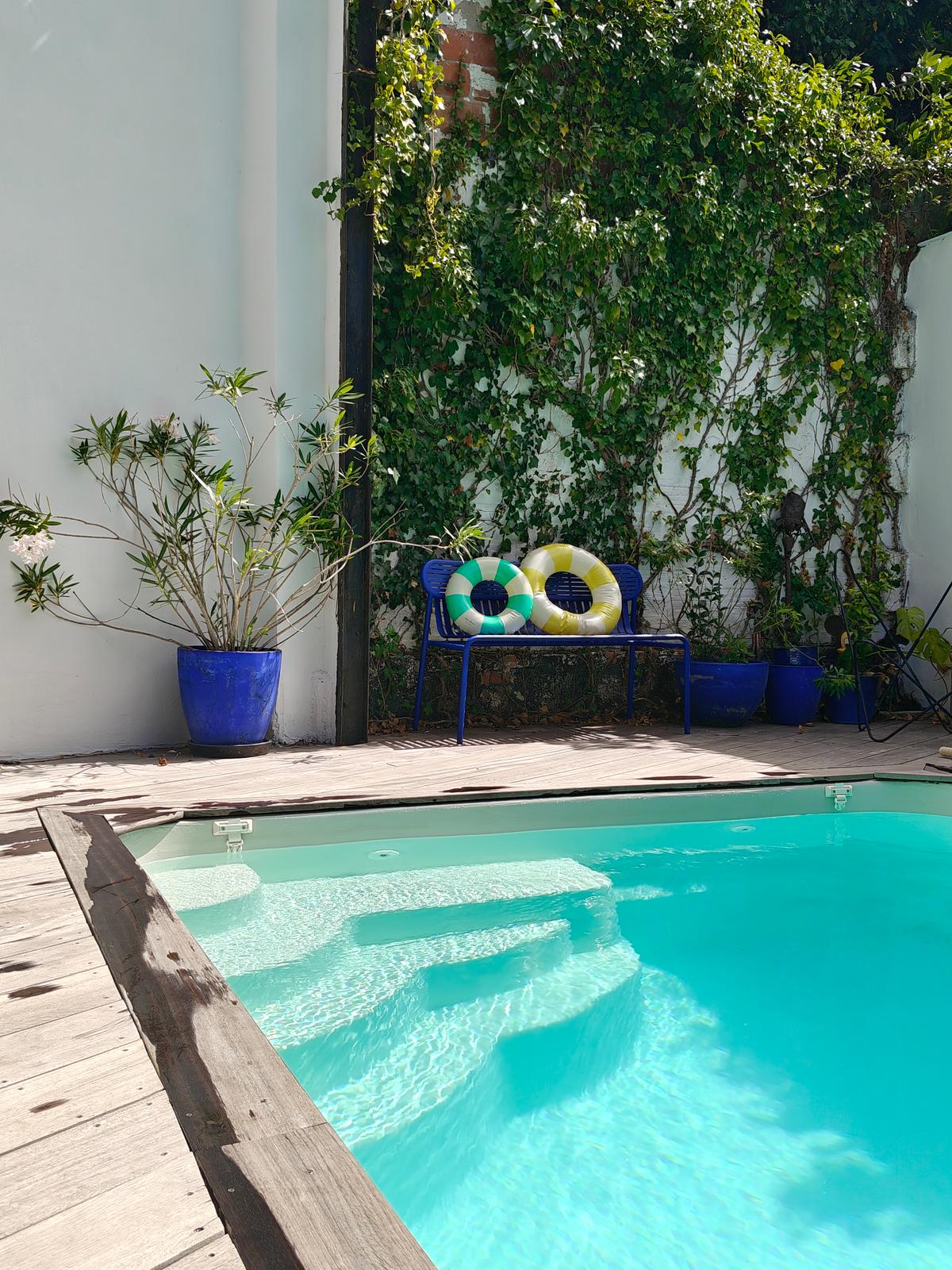 Les marches d'une piscine familiale et des bouées posées sur un banc