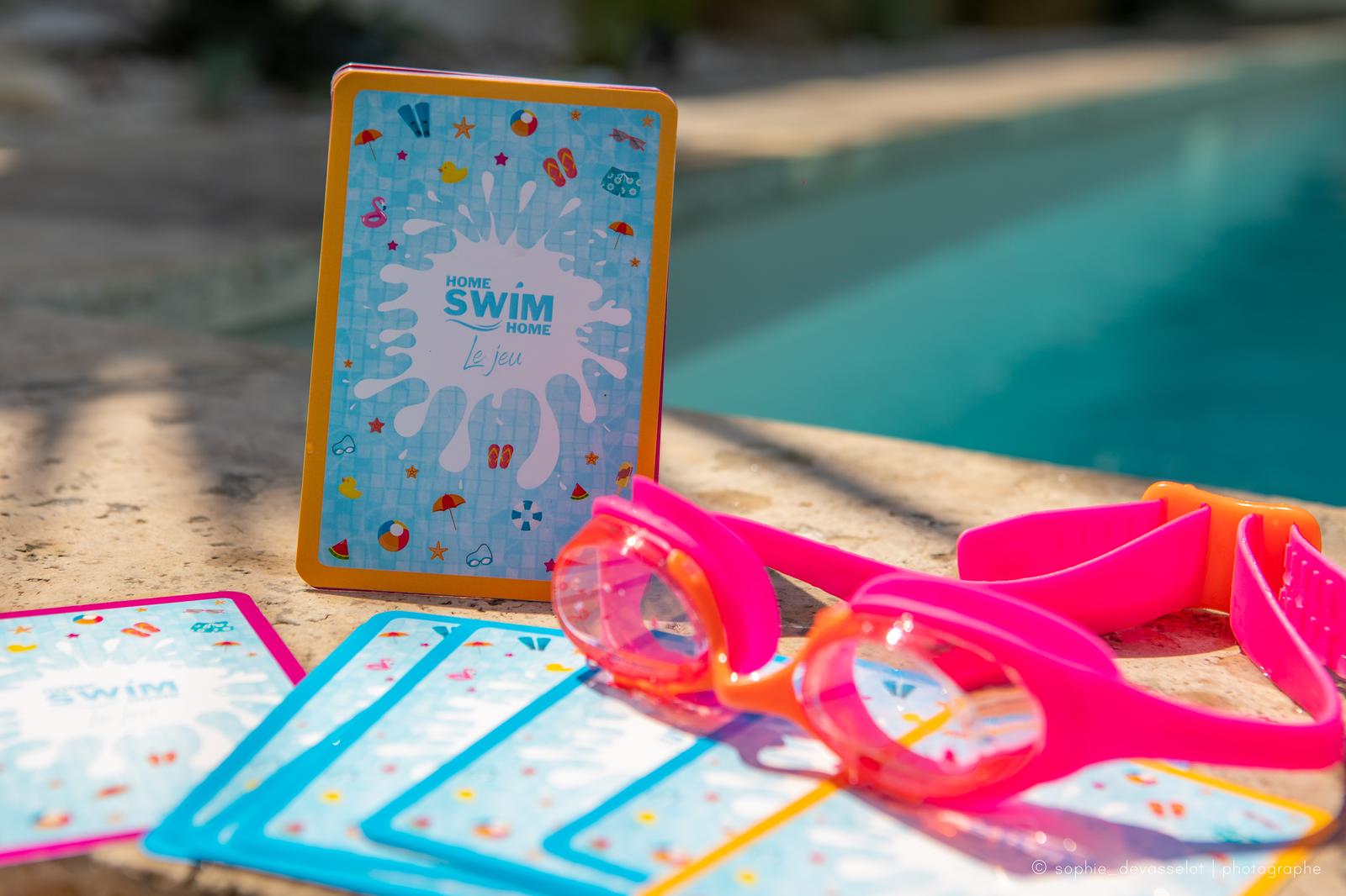 Une carte du jeu et des lunettes de natation roses au bord de la piscine