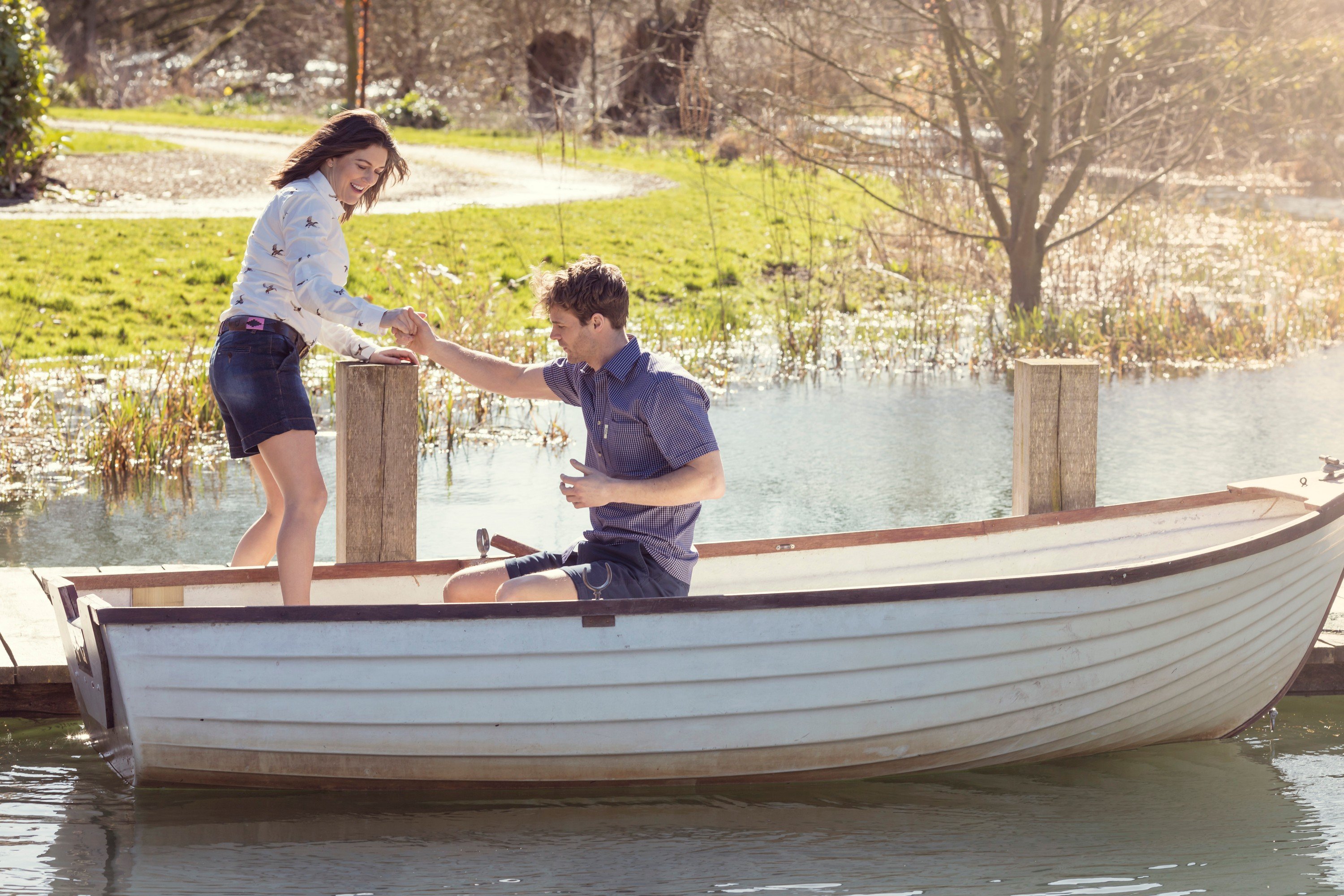 Gentleman helping a lady get onto a boat