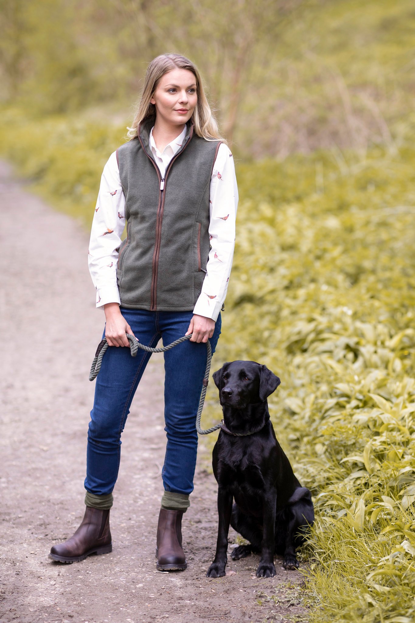 Frau führt einen Hund an einer Schleppleine aus.