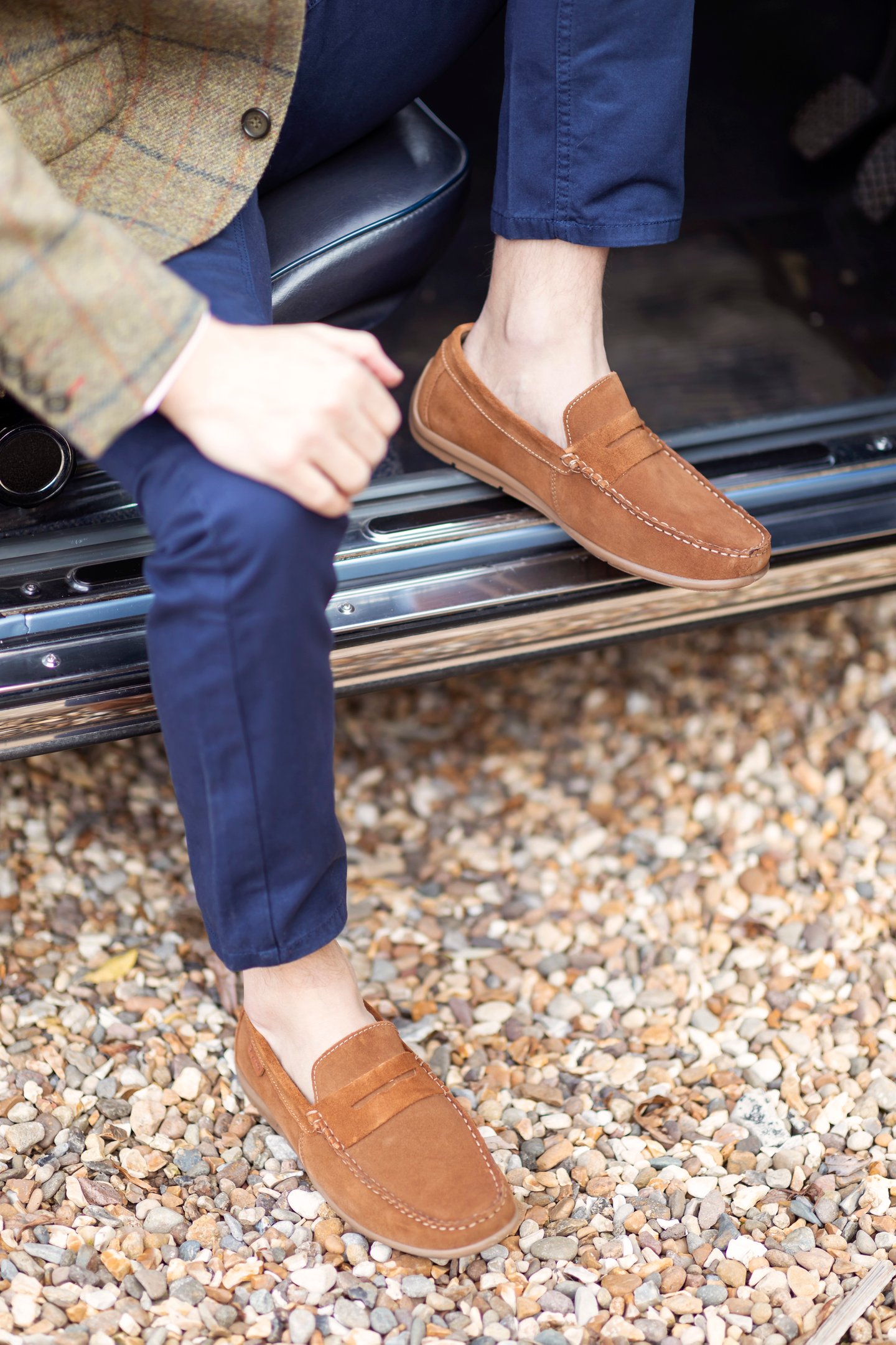 Mocasines de ante color camel para hombre combinados con pantalones chinos azul marino.