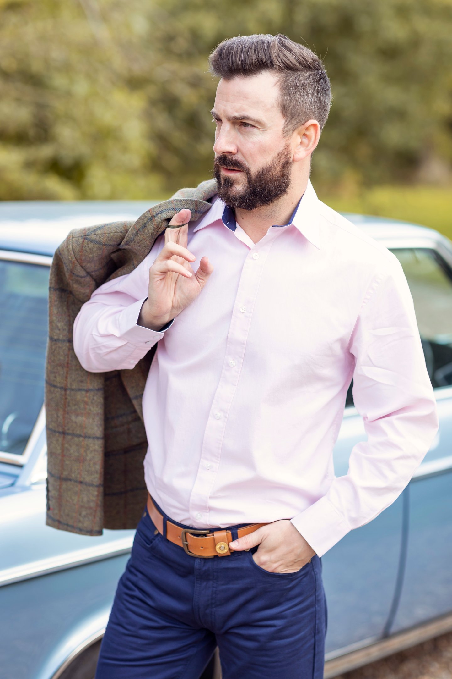 Hombre con una elegante camisa rosa de Poxford, blazer de tweed y pantalones chinos azul marino.
