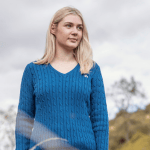 Lady wearing a turquoise blue v-neck cable knit jumper