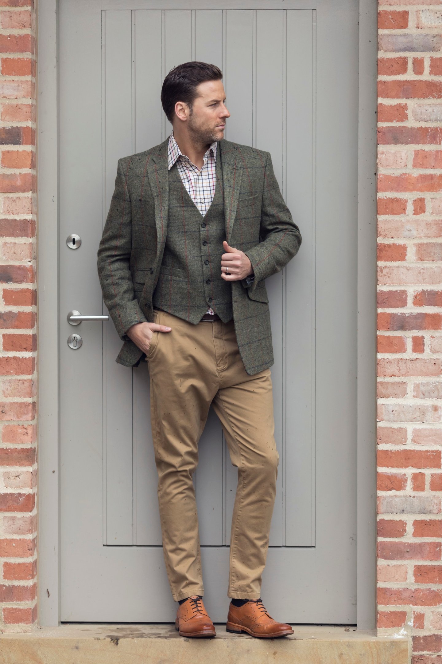 Hombre con chaqueta y chaleco a juego, pantalones chinos y zapatos brogue.
