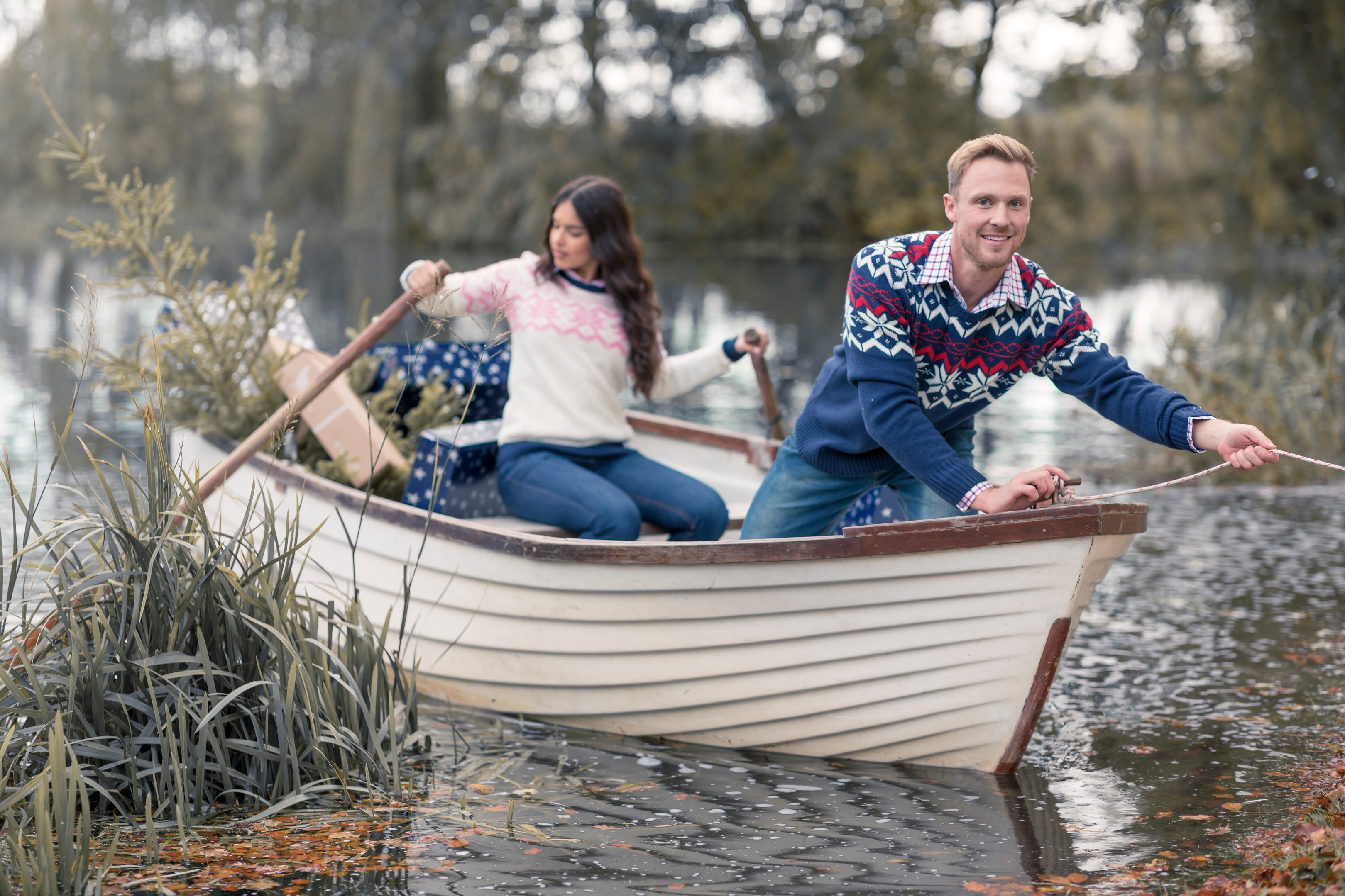 A couple sat on a boat wearing cosy country jumpers