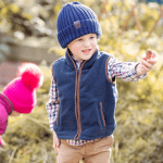 Boy wearing a navy fleece gilet layered with a checked shirt.