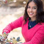 Lady wearing a bright pink v-neck cable knit jumper