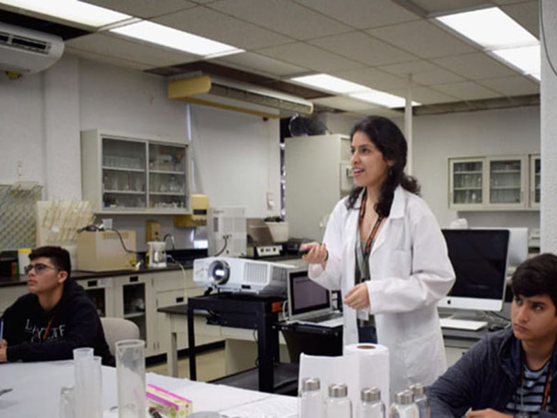 Adriana Santiago-Ruiz (Middle): Explaining details of the materials science experiment to the high school participants at “Experimenta con PREM”