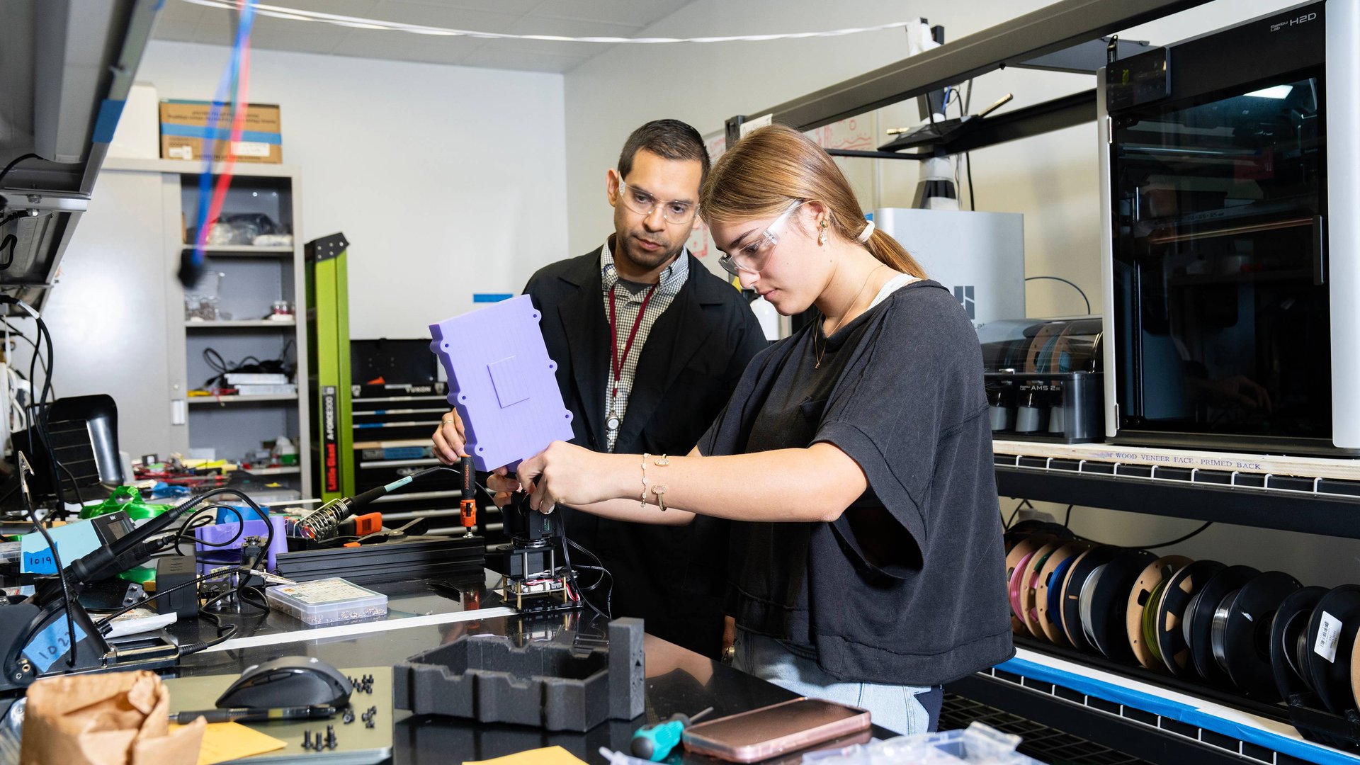 Chris Reyes — co-founder of Material Hybrid Manufacturing — mentors a high school student on battery production. Image courtesy of Texas State University. 