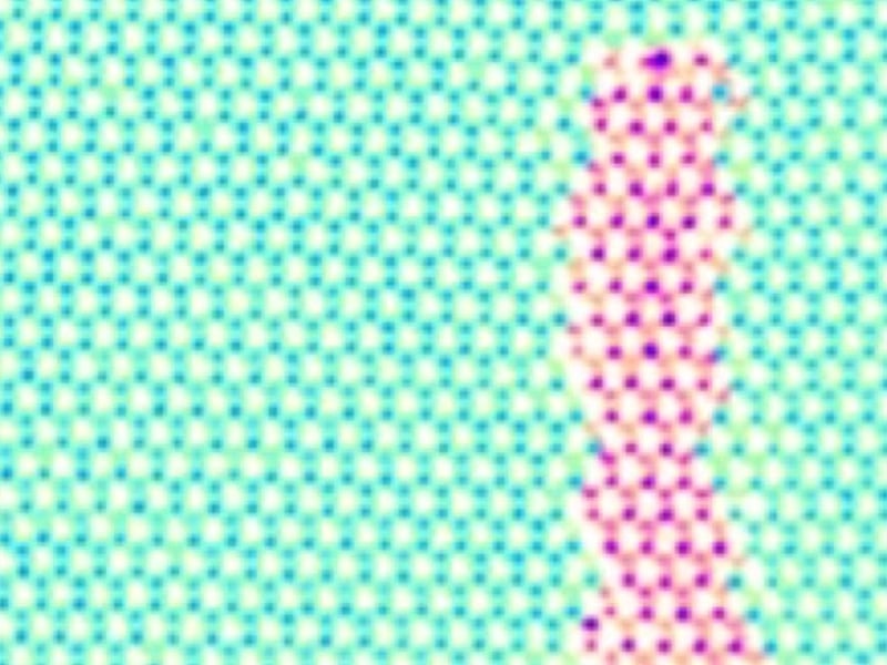 Electron microscope image of a 1-D channel of molybdenum disulfide embedded in 2-D tungsten diselenide. The blue/green dots are tungsten and selenium atoms; the magenta dots are sulfur atoms. The entire film is three atoms thick.