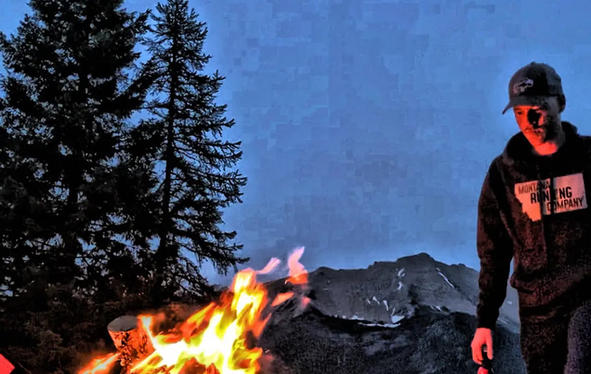 Campfire at a backcountry campsite in Montana, mountains and r-pod behind