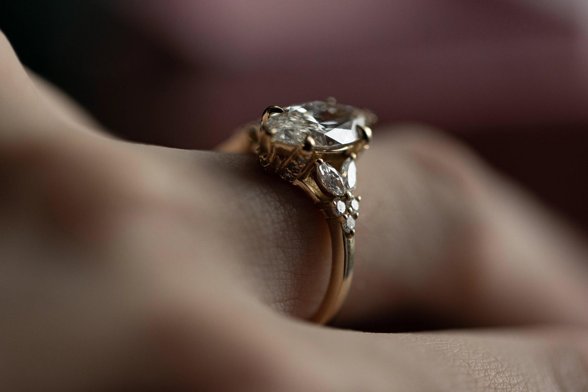 Marquise diamond ring in yellow gold worn on a finger, photographed from the side to show the band profile and the elevated diamond rising from the setting