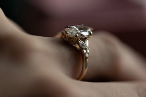 Marquise diamond ring in yellow gold worn on a finger, photographed from the side to show the band profile and the elevated diamond rising from the setting
