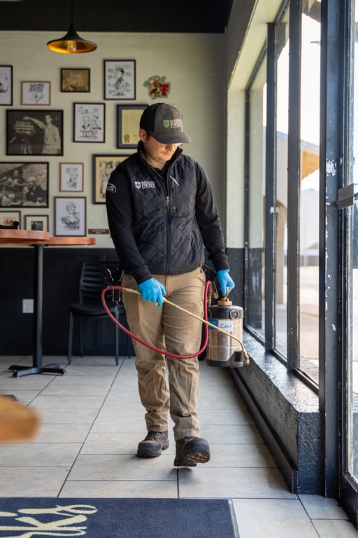 Pest control technician treating the interior of a storefront