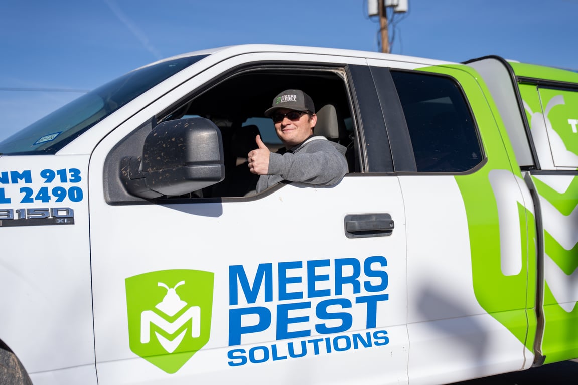 Pest control technician sitting in a service truck