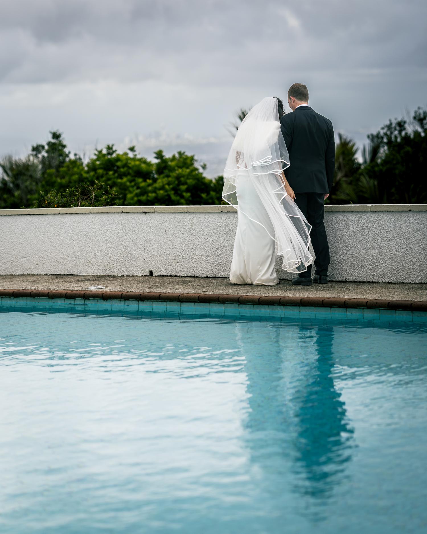 Feby and Steven stand together beside the pool