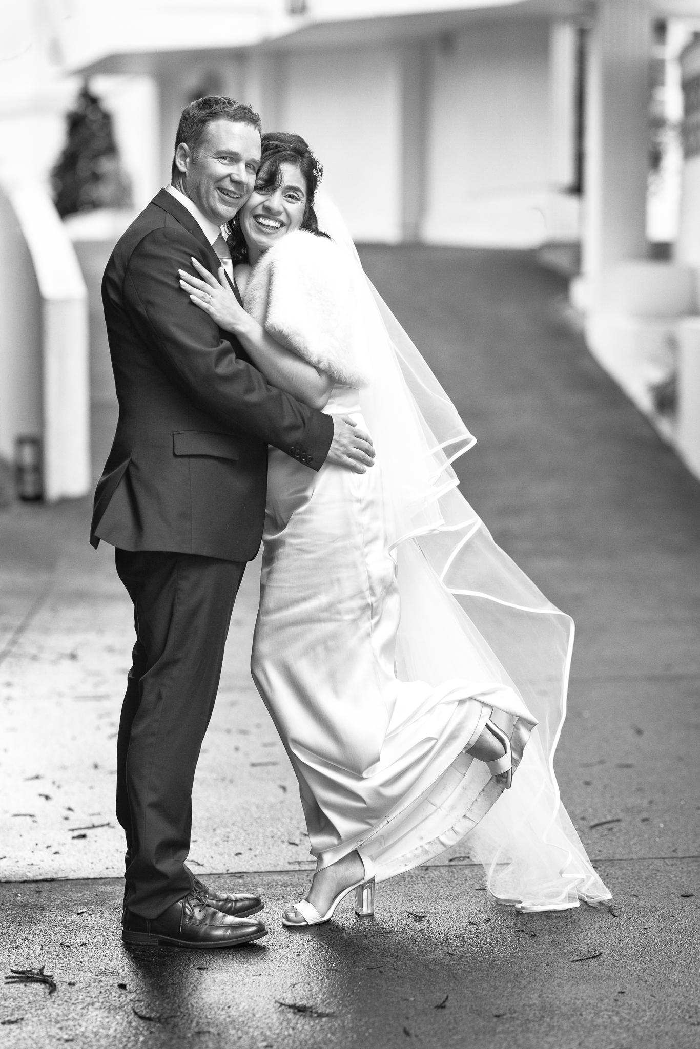 Black and white photo of Feby and Steven dancing on a wet path