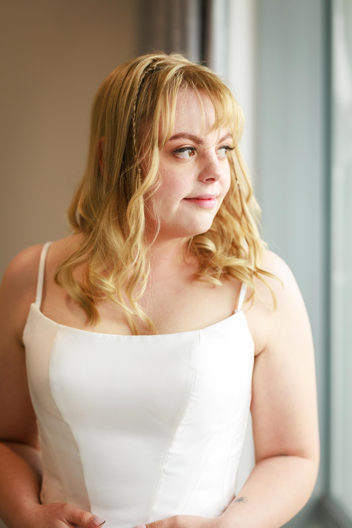 Shannon in her gown by a window during preparations