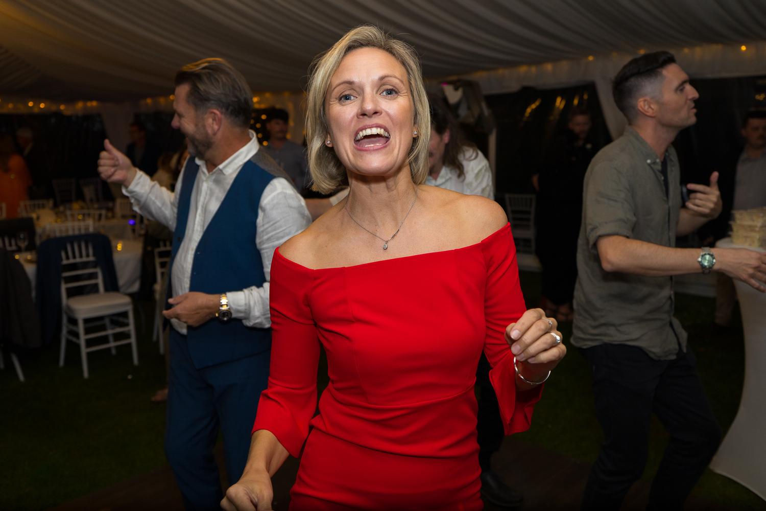 A guest in a red dress dances