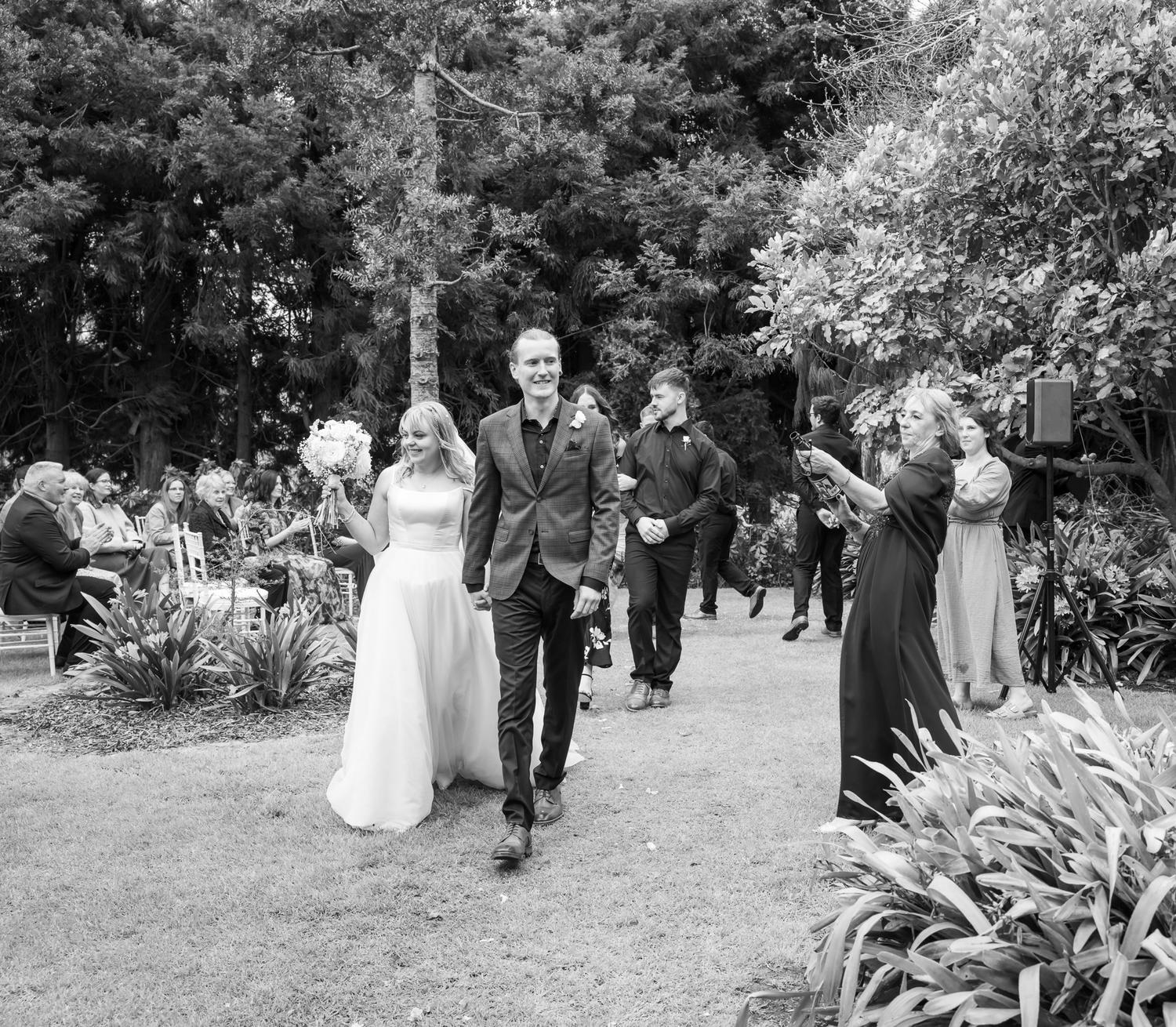 Black and white photo of Shannon and Connor walking back up the aisle