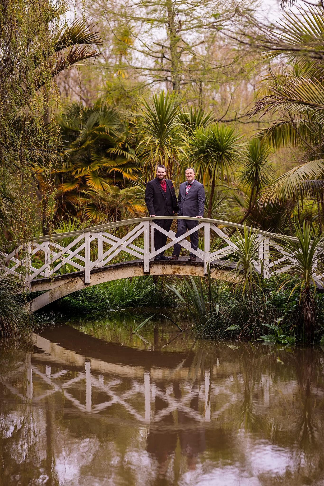 Two men, Josh and Paul, pose for a picture on a bridge