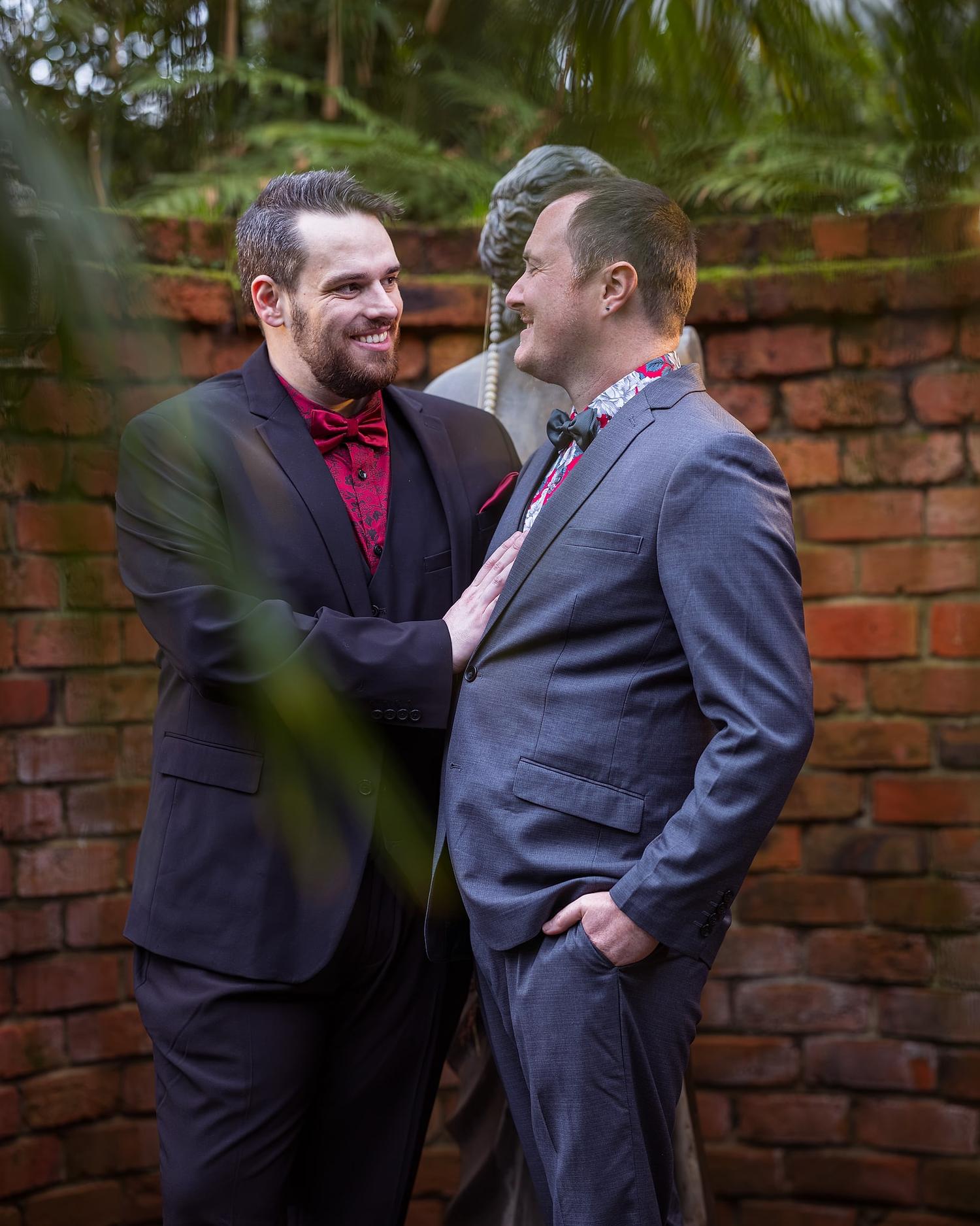 Two men, Josh and Paul, are posing for a picture in front of a statue