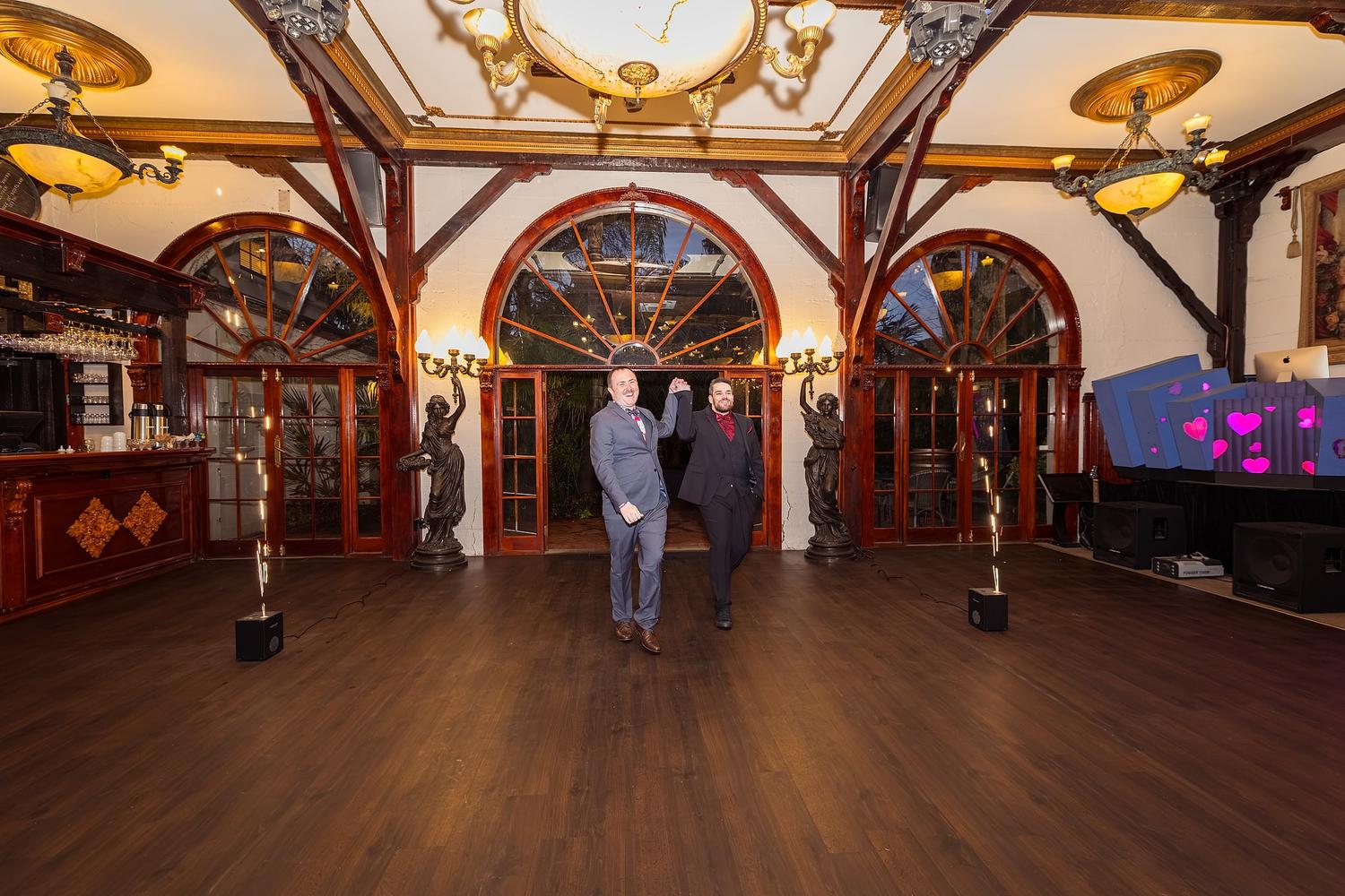 Two men, Josh and Paul, are celebrating their wedding in a grand ballroom