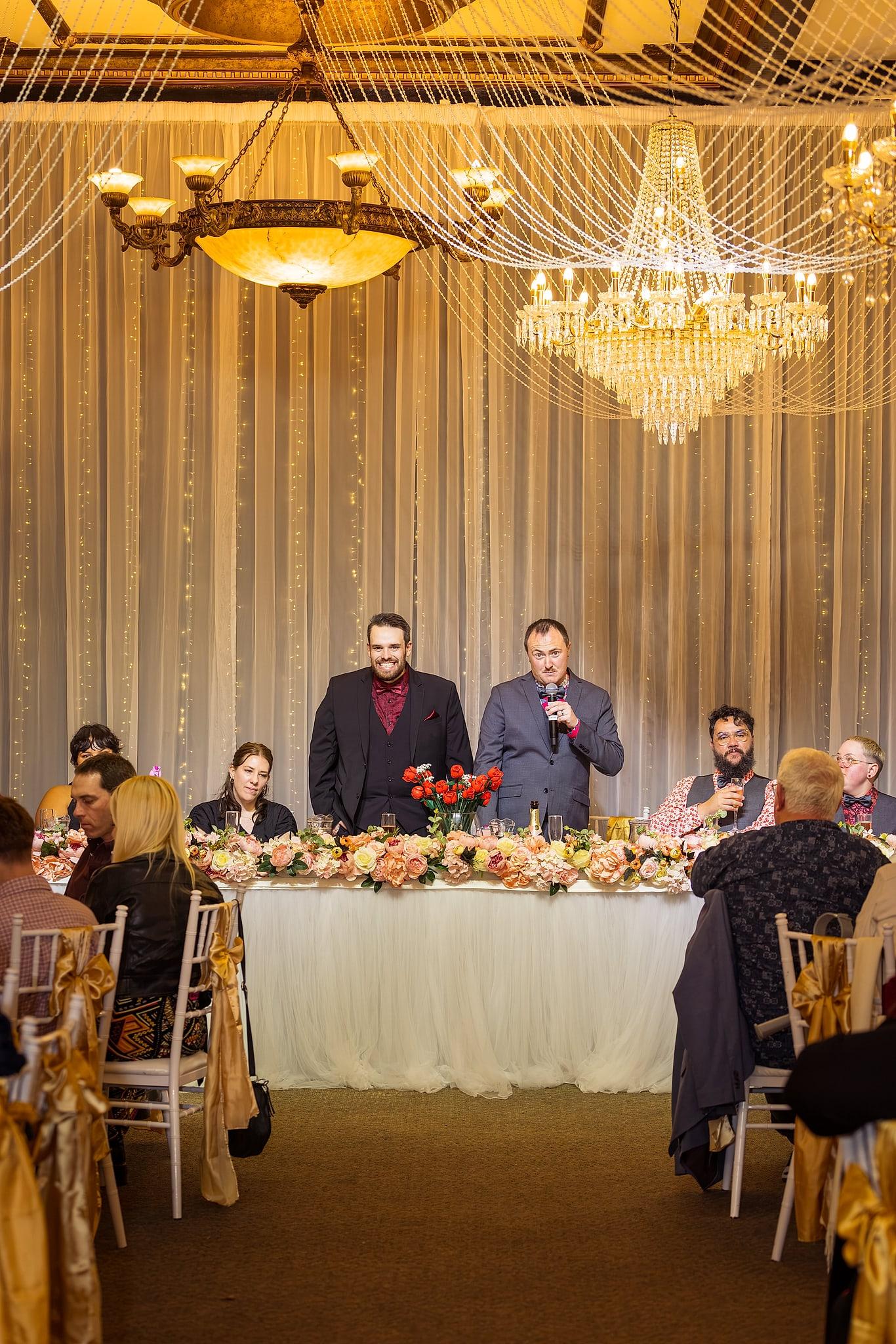 A group of people, including Josh and Paul, are standing in front of a table with a microphone